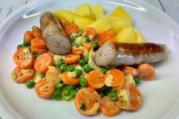Weitere Aufnahme von Bratwurst mit Kartoffeln, Erbsen und Möhren